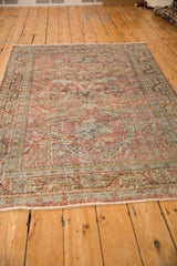 Perspective view of a distressed Persian Mahal rug with a time-softened blush and slate blue design.