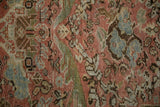 Worn knot heads and foundation visible within the scrolling floral patterns of a distressed Mahal rug.