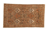 Vintage distressed Bakhtiari rug with repeating shield-like panels in rust, charcoal, and sand.