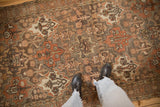 The textured, distressed pile and earthy panel design of a vintage Persian Bakhtiari rug.