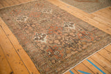 A vintage Bakhtiari rug's repeating panel design in earthy charcoal, rust, and beige tones.