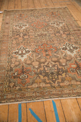 Angled view of a vintage Bakhtiari rug highlighting the worn texture and panel design.