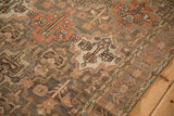 Angled detail of a distressed Bakhtiari rug's starburst border and geometric field in rust and charcoal.