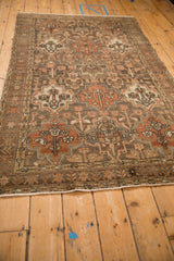 Angled perspective of a vintage Bakhtiari rug with repeating panels in charcoal, rust, and beige.