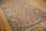 Low angle view across the distressed pile of a Persian Malayer rug with repeating boteh designs.