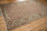 A full-length angled view of a vintage distressed Malayer rug with a repeating boteh pattern.