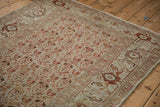 Angled view of a vintage Malayer rug corner showing the turtle samovar border design.