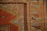 Close-up of the geometric animal border with a low pile in madder red and slate blue.