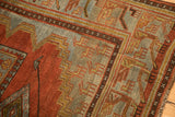Geometric animal border detail in slate blue, madder red, and coffee brown on a low-pile rug.