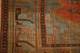 Close-up of the geometric animal main border on the distressed hand-knotted Persian rug.