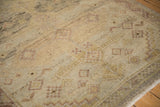 Low pile texture on a distressed Peshawar runner, with geometric field and meandering vine border.