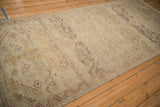 Angled perspective of a distressed Peshawar runner highlighting its even wear and low-pile texture.