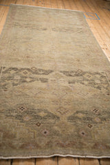 Perspective view down the length of a distressed Peshawar runner with a muted, sandy palette.