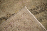 Folded corner of a distressed Peshawar runner showing the hand-knotted back and low pile texture.