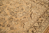 Distressed, low-pile texture of floral blossoms in brown and seafoam on a vintage Arak carpet.