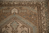 Corner view of a vintage Malayer rug's hexagonal medallion and narrow geometric borders.
