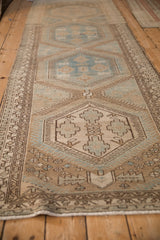 Angled view down the distressed Persian runner, highlighting its repeating hexagonal medallions and soft, even wear.