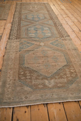 Angled view of a distressed Malayer runner emphasizing its length and repeating medallions.