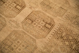 Close-up of the distressed Ersari carpet's low pile showing geometric elephant footprint guls.