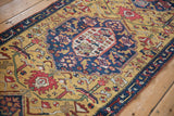 An antique Karabagh runner's shield medallion surrounded by floral arabesques on a gold field.