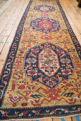A low angle view down the length of the antique Karabagh runner, showing its repeating medallions.