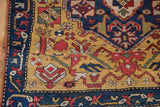 Close-up of the meandering vine border and gold field of a hand-knotted antique Armenian Karabagh rug runner.