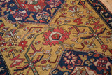 Hand-knotted pile showing a shield medallion with red and blue floral arabesques on a gold field.
