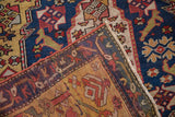 Folded corner of an antique Karabagh rug showing the textured pile with knot heads and reverse weave.