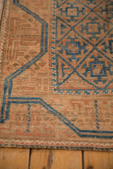 Close-up of the even wear and sapphire blue trellis design on a vintage terracotta Belouch rug.