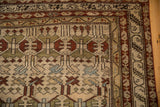 Corner detail of an antique Borchalou rug with scrolled serpent borders and even wear.