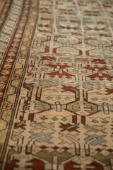 Angled view showing the distressed, low-pile texture and geometric motifs of an antique Borchalou rug.
