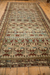 Long perspective view of the distressed Persian Borchalou runner showing its geometric floral pattern.