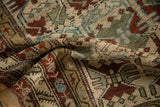 Textured pile of a distressed Persian rug with floral motifs in sand, burgundy, and teal.