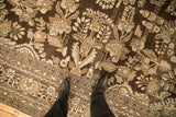 Close view of a vintage Kaboutrahang carpet's distressed texture and coffee brown floral pattern.