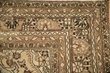 Close-up of the distressed, hand-knotted corner border in shades of coffee and chocolate brown.