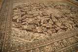 Angled view of a distressed Kaboutrahang carpet's floral pattern in rich chocolate brown and silver tones.