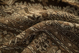 Textured weave of a distressed Persian rug with floral details in chocolate brown, silver, and pale blue.