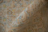 A rolled vintage Agra carpet showing the detailed texture of its short, distressed cotton pile.