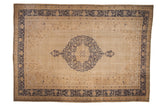 Distressed vintage Oushak rug featuring a large, cobalt blue medallion on a sand-colored open field.