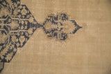 Distressed Oushak carpet pile showing mostly even wear and the exposed foundation.