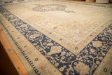 Worn texture across the corner of a distressed Oushak carpet, showing its cobalt blue and ivory border.