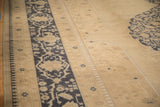 Low-pile texture of the distressed Oushak's border with cobalt blue and antique ivory motifs.