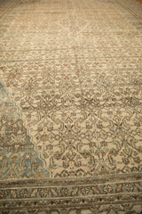 Angled view over a distressed Persian carpet showing its turtle samovar border and worn pile.