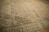 Prominent color abrashes in dusty teal and beige tones seen across the distressed, low-pile rug.