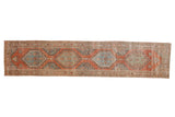 Vintage distressed Persian runner with repeating hexagonal medallions in faded red, powder blue, and green.