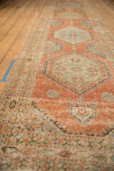 Angled view highlighting the time-softened texture and repeating medallions on a vintage Persian runner.