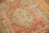 Distressed hexagonal medallion in jade green and terracotta red on a vintage Northwest Persian runner.
