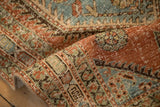 Worn, hand-knotted texture of the cartouche border in red, powder blue, and jade green.