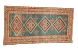Vintage distressed Malayer rug with a column of diamond medallions on an abrashed sky blue field.