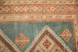 Intricate geometric border of a distressed Malayer rug with a low pile and abrashed blue field.